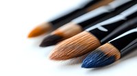 Professional art brushes with natural bristles in row, selective focus on blue brush tip against white background, macro photography for cosmetic and fine art.