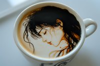 Creative latte art featuring female portrait with flowing hair drawn in coffee foam, artistic beverage presentation against white background.