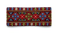 Traditional ethnic embroidered textile border with colorful floral geometric patterns on red fabric background isolated on white for design projects.