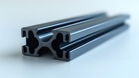 Black aluminum extrusion profile on light background shows industrial construction material with precise engineering detail and metallic surface finish.