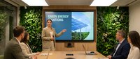 Professional businesswoman presenting green energy solutions with solar panels and wind turbines to corporate team in modern eco-friendly office meeting room.