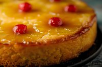 Upside-down cake with caramelized pineapple rings and maraschino cherries on golden sponge, perfect for bakery, dessert, and food photography projects.