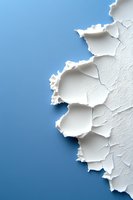 Peeling white paint or plaster texture on blue background creating abstract coastal cliff-like pattern with rough, torn edges and natural shadowing effect.