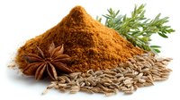 Aromatic ground cumin powder heap with star anise, caraway seeds and fresh rosemary sprigs on white background for culinary use.