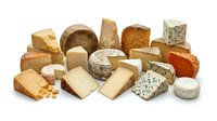 Assorted gourmet cheese collection featuring hard, soft, aged and blue varieties isolated on white background for culinary and food design projects.