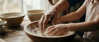 Potter hands shaping clay on spinning wheel in ceramic workshop studio. Traditional craftsmanship and artisan pottery making process for handmade ceramics.