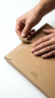 Male hands opening kraft paper cardboard box on white background. Unboxing delivery package for e-commerce, shipping, logistics, retail, and online shopping concepts.