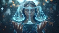 Glowing blue scales of justice hologram floating above female hands against dark background with bokeh lights and magical particle effects.