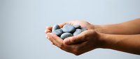 Hands holding handful of blueberries against white background, representing fresh fruit, healthy eating, organic produce, and natural nutrition for food and wellness concepts.