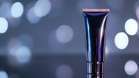 Metallic cosmetic tube on dark background with bokeh lights. Luxury skincare product packaging mockup for beauty industry and cosmetic branding designs.