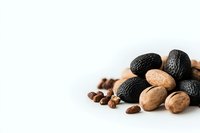 Mixed nuts and dried black figs arranged on white background, minimalist food composition with natural healthy snacks and coffee beans for wellness concept.