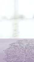Ornate mandala pattern embossed on lavender paper with soft-focus blurred background, suitable for wellness, meditation, spirituality, and design projects.