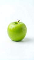 Fresh green apple with water droplets isolated on white background, ready for food and nutrition design projects.