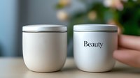 Two minimalist cosmetic jars with silver lids on wooden surface, one labeled Beauty, clean skincare packaging mockup for branding and product presentation.