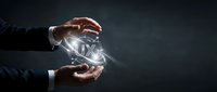 Businessman hands protecting glowing UX letters with light effects on dark background representing user experience design and digital innovation.