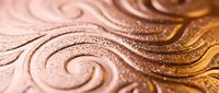 Elegant swirling patterns carved in warm copper surface with intricate spiral designs and metallic texture for luxury decorative backgrounds and artistic projects.