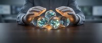 Businessman in suit holding glowing crystal spheres representing global connectivity, technology, and future business growth on dark desk.