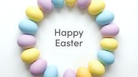 Pastel colored Easter eggs arranged in a circle wreath with Happy Easter text on white background, spring holiday greeting card.