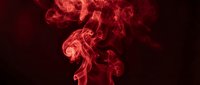 Red smoke swirling on dark background, abstract crimson fog with dramatic curls and waves creating a mysterious atmospheric effect.