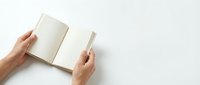 Hands holding open blank notebook with empty pages on white background for writing, journaling, planning and creative projects.