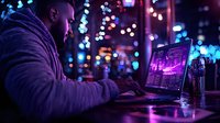African American male trader analyzing financial charts and market data on laptop in dark room with colorful bokeh lights, working late at night in urban setting.