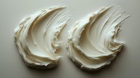 Creamy white frosting swirls on neutral background showing rich texture and smooth peaks, ideal for bakery and confectionery marketing materials.