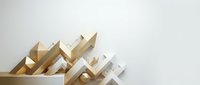 Wooden and white geometric arrow shapes pointing upward on neutral background, symbolizing growth, progress and business success.