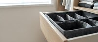 Wooden drawer organizer with fabric compartments for storing accessories, jewelry, and small items in bedroom or closet storage solutions.