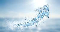 Dynamic water splash with droplets frozen in motion against soft blue sky background for refreshing beverage and wellness campaigns.