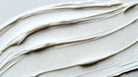 Smooth creamy white frosting texture with diagonal swirls and ridges creates elegant minimalist background pattern for culinary and design projects.