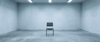 Single black chair positioned in empty concrete room with fluorescent ceiling lights, minimalist interior space suitable for conceptual, business, or editorial design projects.