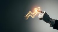 Businessman hand holding glowing upward arrow symbol representing financial growth, profit increase, and business success on dark background.