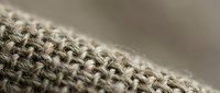 Natural burlap fabric texture with woven hemp fibers in close-up macro detail showing organic textile pattern for rustic craft and eco-friendly design projects.