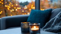Cozy autumn evening with glowing candles, soft knitted blanket and decorative pillows on balcony. Warm bokeh lights create romantic atmosphere for relaxation.