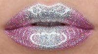 Closeup of lips with glittery makeup in shades of purple and silver, featuring sparkly cosmetic glitter applied for glamorous beauty look and special occasion styling.