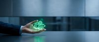 Close-up of a businessman's hand holding a glowing green gear icon, symbolizing technology, innovation, and industrial solutions for business operations.