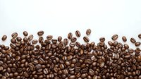 Fresh roasted coffee beans scattered in wave pattern on white background, creating natural border design for cafe menu, packaging and promotional materials.