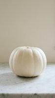 White pumpkin on rustic wooden table against neutral beige wall background for autumn harvest seasonal decoration and fall home decor styling.