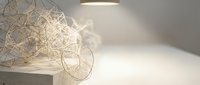 Modern minimalist interior with geometric wire sculpture and warm ambient lighting creating elegant shadows on neutral background for contemporary design.