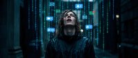 Young man with long hair surrounded by glowing digital icons and data streams in futuristic cyber environment for technology concepts.