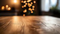 Wooden table surface with warm bokeh lights in background creating cozy atmosphere for product display or festive setting.