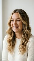 Happy blonde woman laughing in cream sweater with wavy hair against neutral background for lifestyle and wellness content.