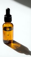 Amber glass dropper bottle filled with golden essential oil or serum, featuring black pipette cap, isolated on white background with dramatic shadow for skincare and wellness product marketing.