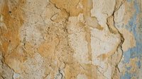 Weathered cracked wall surface with peeling paint layers showing aged texture and natural deterioration patterns for vintage design projects.