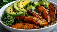 Glazed carrot slices with avocado, quinoa and kale in white bowl, healthy lunch or dinner meal for nutrition and wellness content.