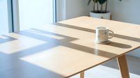Wooden desk with mug in bright sunlit office space, minimalist workspace with natural light and potted plant for modern business environment.