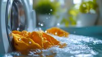 Fresh orange slices in splashing crystal clear water with water drops and bubbles against blurred turquoise background, macro photography for refreshing drink concept.
