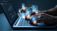 Digital real estate technology concept with glowing property icons floating above laptop keyboard for online property management and investment platforms.