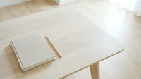 Blank open notebook with pencil on wooden table next to closed notepad, suitable for journaling, planning, education, and office design projects.