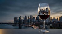 Wine glass with city skyline reflection at sunset creating elegant urban dining atmosphere for luxury lifestyle and fine dining concepts.